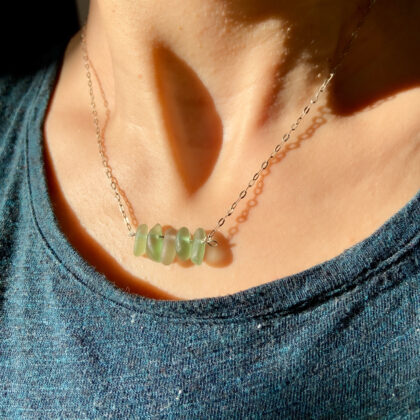 Green sea glass pendant necklace on silver chain coastal style handmade Minimalist green sea glass necklace worn on neck in natural sunlight Handmade green sea glass necklace inspired by the ocean Tunisia Natural green sea glass jewelry on silver chain beach inspired necklace